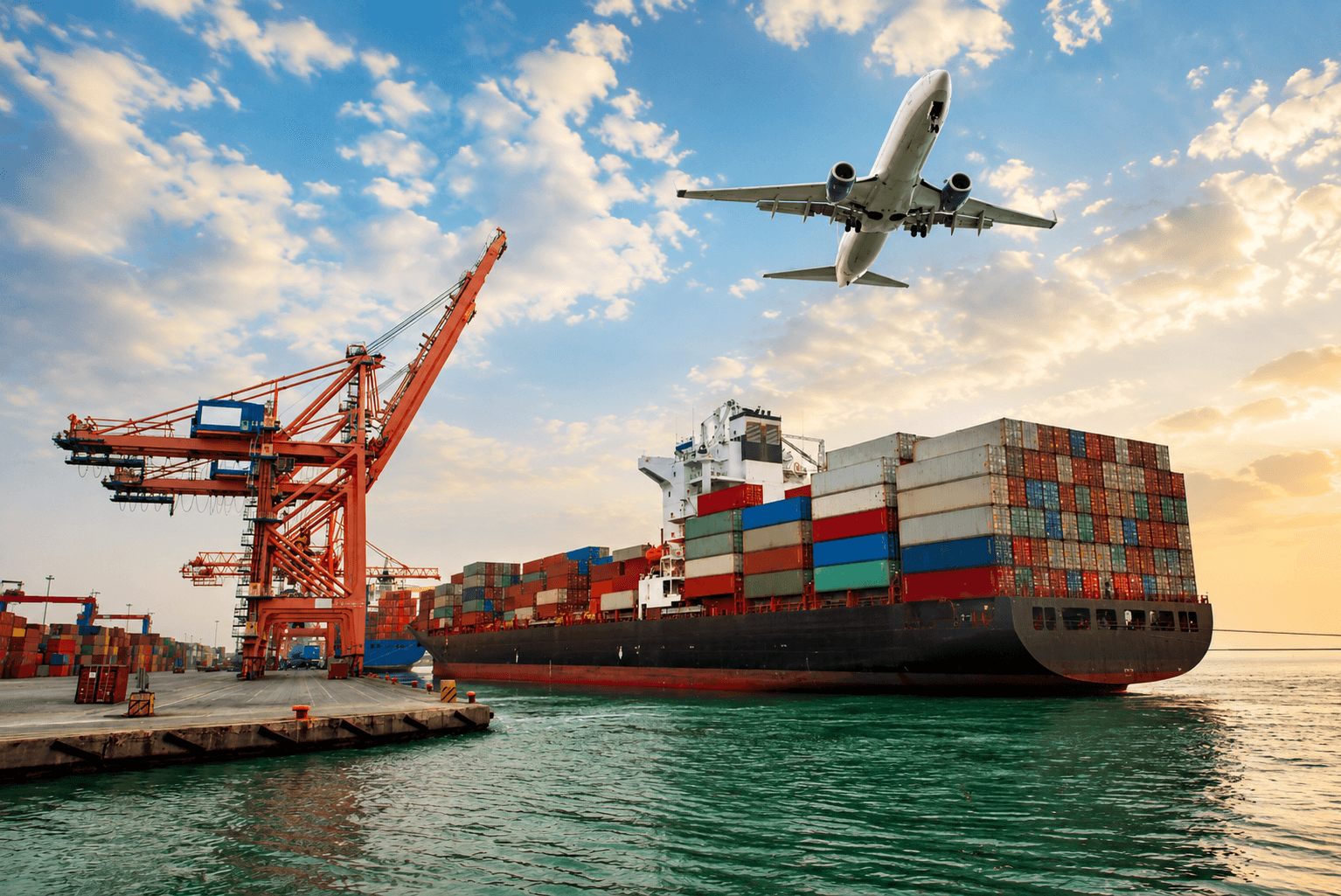 Container ship, port crane, and aircraft at a multimodal logistics hub